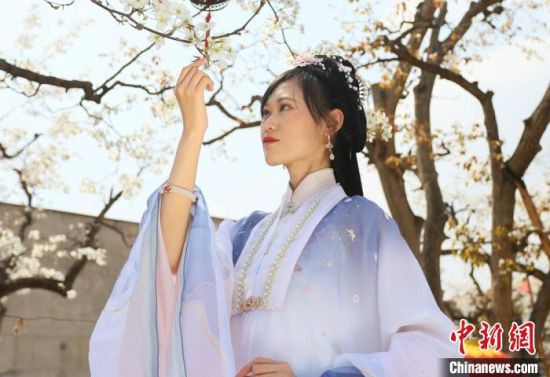 圖為蘭州青年身穿漢服在百年梨園賞景?！「哒?攝