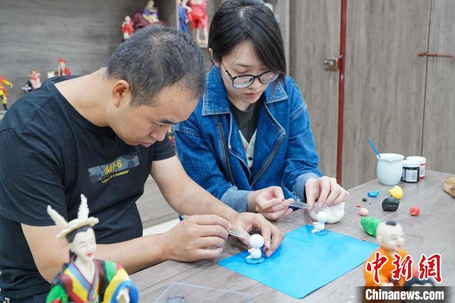 <a target='_blank'  data-cke-saved- >中新社</a>記者(右)現(xiàn)場體驗(yàn)面塑制作過程。　陳爭強(qiáng) 攝