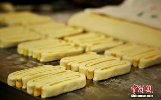 圖為面劑被涂上胡麻油，切成條狀用作月餅的花型制作。張文 攝