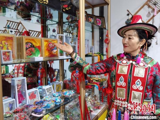 圖為身著民族服飾的隴原巧手展示手工藝品。(資料圖) 徐雪 攝