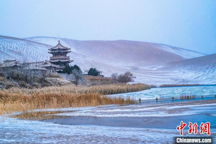 2021年11月28日，雪落鳴沙山月牙泉景區(qū)?！⊥醣筱y 攝