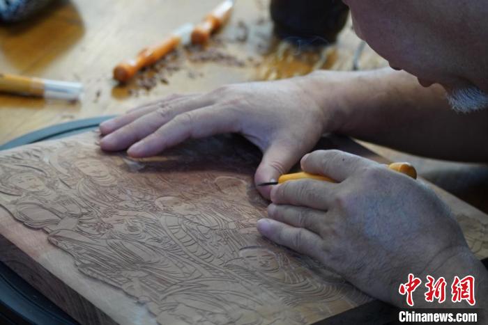 圖為徐晉林湊近木板，近距離制作雕版畫?！【琶赖┰?　攝