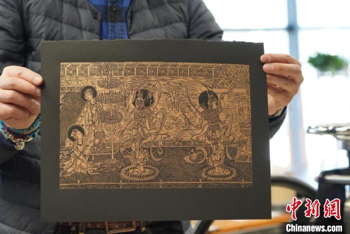 圖為手工書藝人展示敦煌雕版壁畫印刷品?！【琶赖┰?　攝