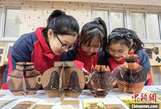 圖為學(xué)生用紙創(chuàng)作的立體彩陶?！⒂裉?攝