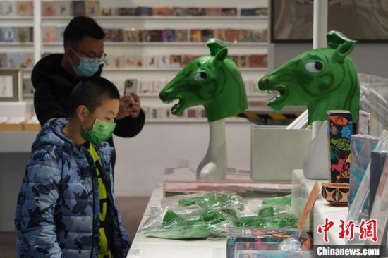 圖為“神馬來了”銅奔馬頭套吸引參觀者駐足?！【琶赖┰?攝