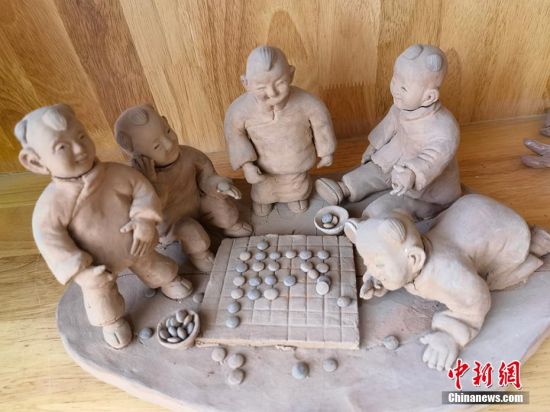 圖為泥塑作品展現(xiàn)下棋場(chǎng)景。 劉玉桃 攝