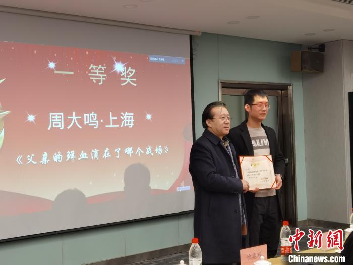 圖為作家、西北師范大學(xué)新聞與傳媒學(xué)院院長徐兆壽頒發(fā)一等獎證書，代領(lǐng)獎?wù)呱吓_領(lǐng)獎?！钅?攝