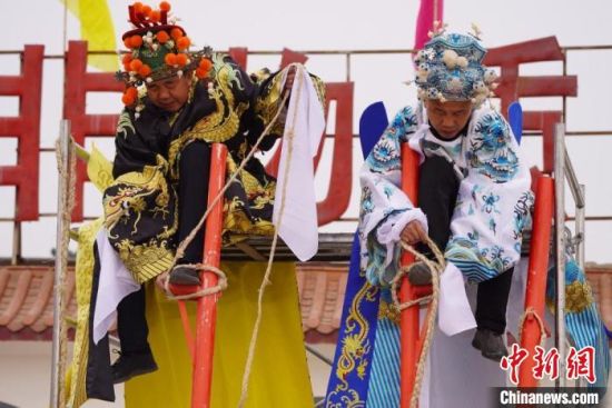 圖為“苦水高高蹺”表演者通過麻繩將腳固定在腳踏板，并在腿部纏繞六七圈?！【琶赖┰?攝