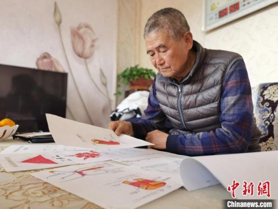 圖為陸鵬飛向記者展示多年帶隊(duì)的手寫筆記?！堟?攝