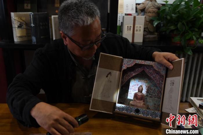 圖為讀者出版集團讀者晉林工作室獨立出品人徐晉林，展示互動性強的敦煌題材手工書。(資料圖) 楊艷敏 攝