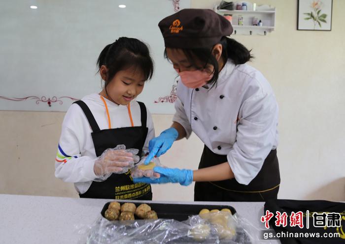 圖為在甘臺胞小朋友在工作人員指導(dǎo)下制作月餅。九美旦增 攝