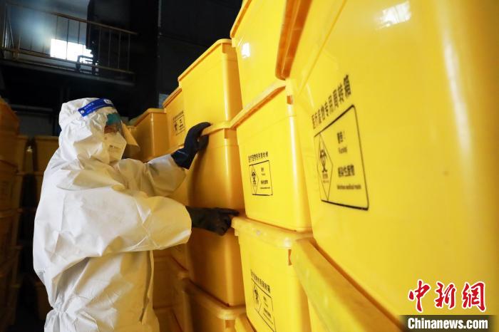 圖為工作人員搬運(yùn)醫(yī)療廢物專用周轉(zhuǎn)箱?！∥航ㄜ?攝