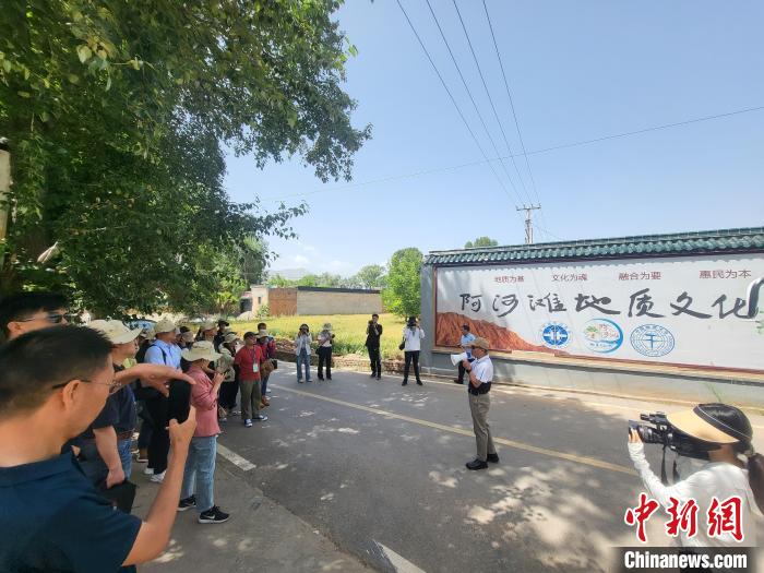 圖為中國地質(zhì)大學(xué)(北京)教授張緒教介紹村落情況?！『衍?攝