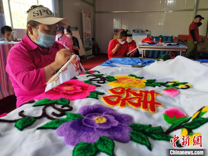 圖為婦女制作青繡?！?zhí)砀?攝
