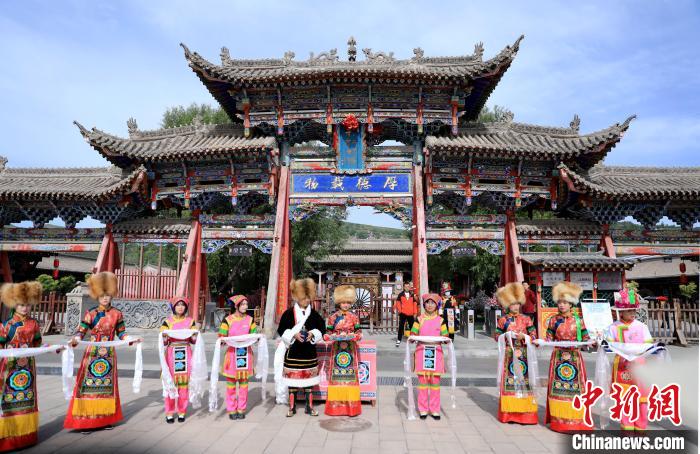 圖為身穿土族服飾的工作人員迎接訪客?！⊙Φ?攝