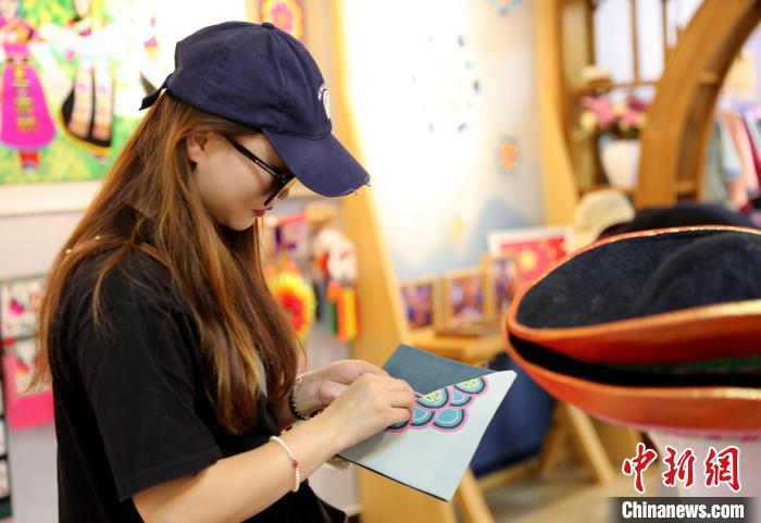 圖為民眾體驗國家級非遺項目盤繡技藝?！⊙Φ?攝