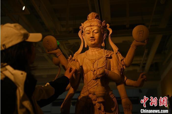 圖為季茂杰觀察自己創(chuàng)作的敦煌木雕。李亞龍 攝</p>
<p>