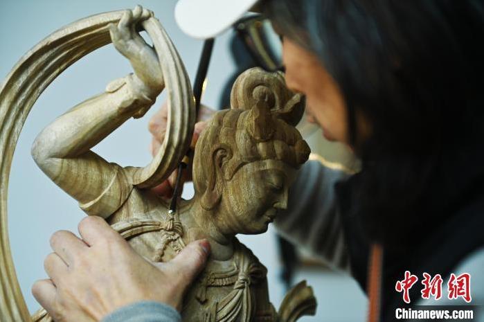 圖為季茂杰進(jìn)行敦煌元素的木雕創(chuàng)作。李亞龍 攝</p>
<p>