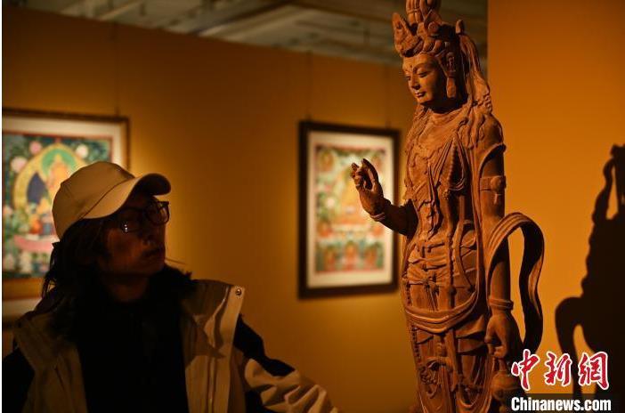 圖為季茂杰觀察自己創(chuàng)作的敦煌木雕。李亞龍 攝</p>
<p>