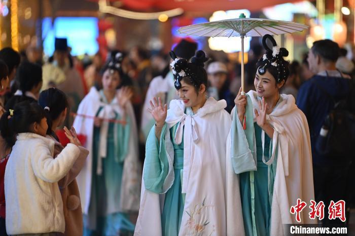 圖為街區(qū)人員著傳統(tǒng)服飾與游人互動(dòng)。李亞龍 攝</p><p>