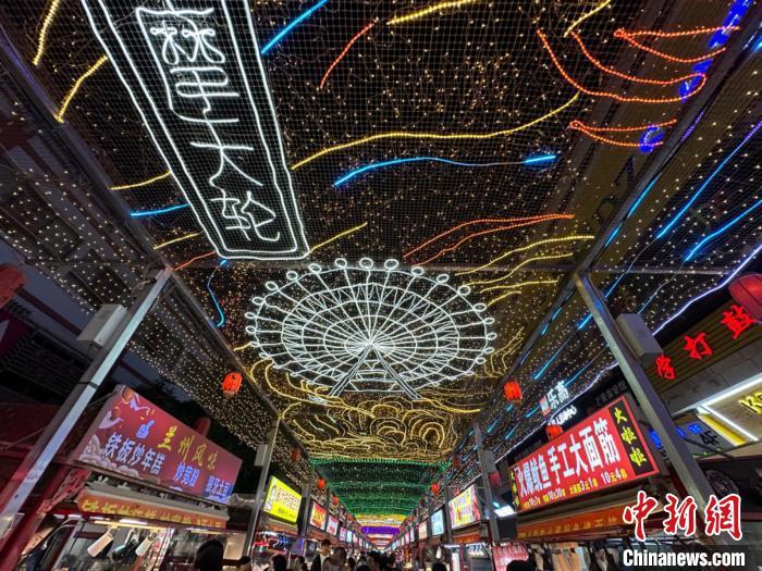 圖為明清街夜市燈光點(diǎn)亮具有武威文化元素的“摩天輪”彩燈。　戴文昌 攝</p><p>