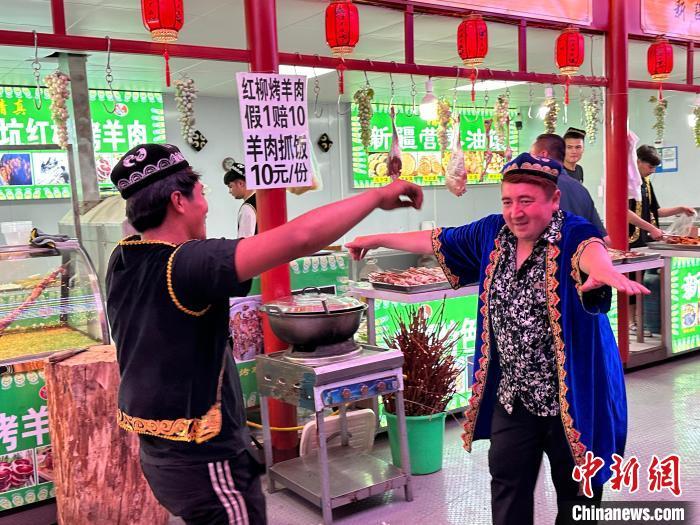 圖為餐飲經(jīng)營者在“西涼不夜城”跳起舞蹈引客。　戴文昌 攝</p><p>