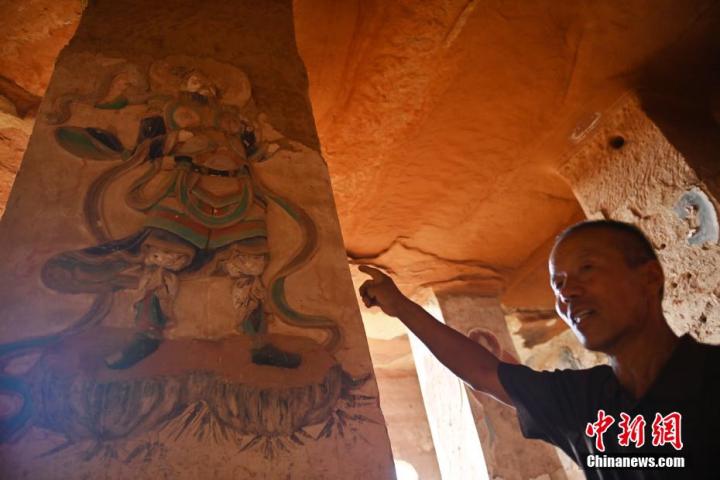 7月15日，甘肅省平?jīng)鍪袥艽h百里石窟長廊羅漢洞石窟內(nèi)，該窟文保員郭建平介紹窟內(nèi)石刻彩繪壁畫。郭建平家中三代人曾自發(fā)保護羅漢洞石窟。羅漢洞石窟遺存40余個窟龕，以北魏至清代風格為主。中新社記者 李亞龍 攝</p>
<p>