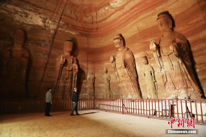 7月15日，游人參觀甘肅省平?jīng)鍪袥艽h百里石窟長廊中的南石窟寺1號窟。百里石窟長廊位于涇川縣境內(nèi)，由512個石窟、5眼窟中石井組成，現(xiàn)存王母宮石窟、鳳凰山石窟、南石窟寺、丈八寺石窟、羅漢洞石窟、太山寺石窟等規(guī)模較大的石窟群，還有數(shù)量眾多的小石窟群。南石窟寺開鑿于北魏永平三年，其中1號窟屬于大型七佛窟，七佛高達6米。中新社記者 李亞龍 攝