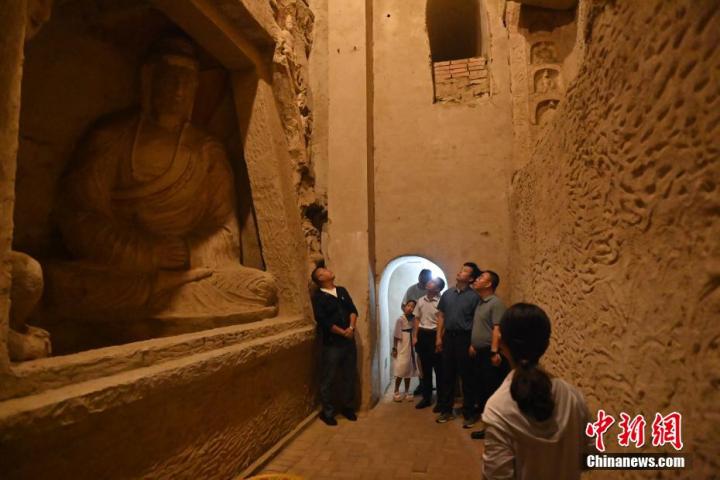 7月15日，游人參觀甘肅省平?jīng)鍪袥艽h百里石窟長廊中的王母宮石窟。百里石窟長廊位于涇川縣境內(nèi)，由512個石窟、5眼窟中石井組成，現(xiàn)存王母宮石窟、鳳凰山石窟、南石窟寺、丈八寺石窟、羅漢洞石窟、太山寺石窟等規(guī)模較大的石窟群，還有數(shù)量眾多的小石窟群。王母宮石窟又名千佛洞，該窟設(shè)計宏大，造像生動，窟內(nèi)擁有造像數(shù)百尊，是較為珍貴的佛教文化歷史遺存。中新社記者 李亞龍 攝</p>
<p>