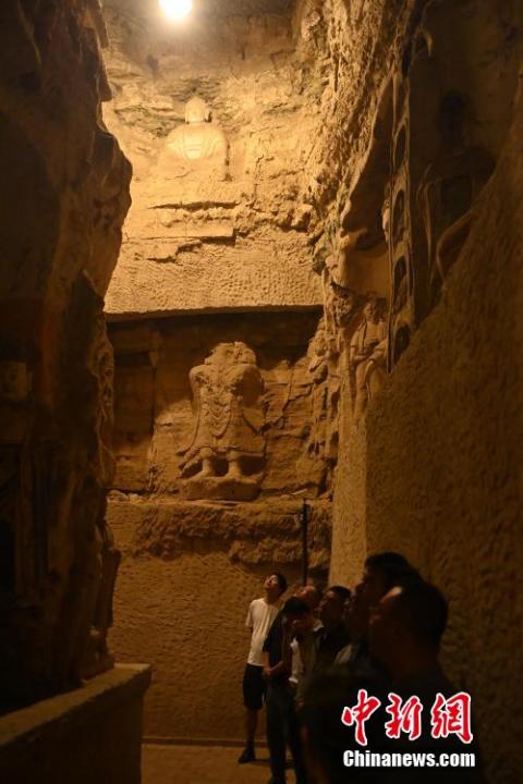 7月15日，游人參觀甘肅省平?jīng)鍪袥艽h百里石窟長廊中的王母宮石窟。百里石窟長廊位于涇川縣境內(nèi)，由512個石窟、5眼窟中石井組成，現(xiàn)存王母宮石窟、鳳凰山石窟、南石窟寺、丈八寺石窟、羅漢洞石窟、太山寺石窟等規(guī)模較大的石窟群，還有數(shù)量眾多的小石窟群。王母宮石窟又名千佛洞，該窟設(shè)計宏大，造像生動，窟內(nèi)擁有造像數(shù)百尊，是較為珍貴的佛教文化遺存。中新社記者 李亞龍 攝</p>
<p>
