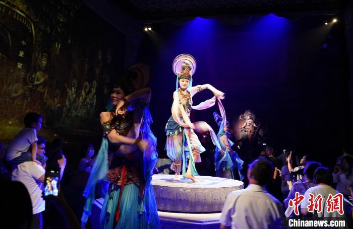 《樂動敦煌》是全球首部洞窟式沉浸體驗劇，利用真人與數(shù)字影像虛實交換實現(xiàn)沉浸式體驗。圖為2023年8月28日晚，《樂動敦煌》演出。(資料圖)中新社記者 毛建軍 攝