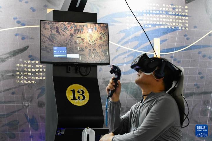 7月22日，游客借助VR設(shè)備沉浸式游覽莫高窟第285窟虛擬場(chǎng)景。新華社記者 郎兵兵 攝